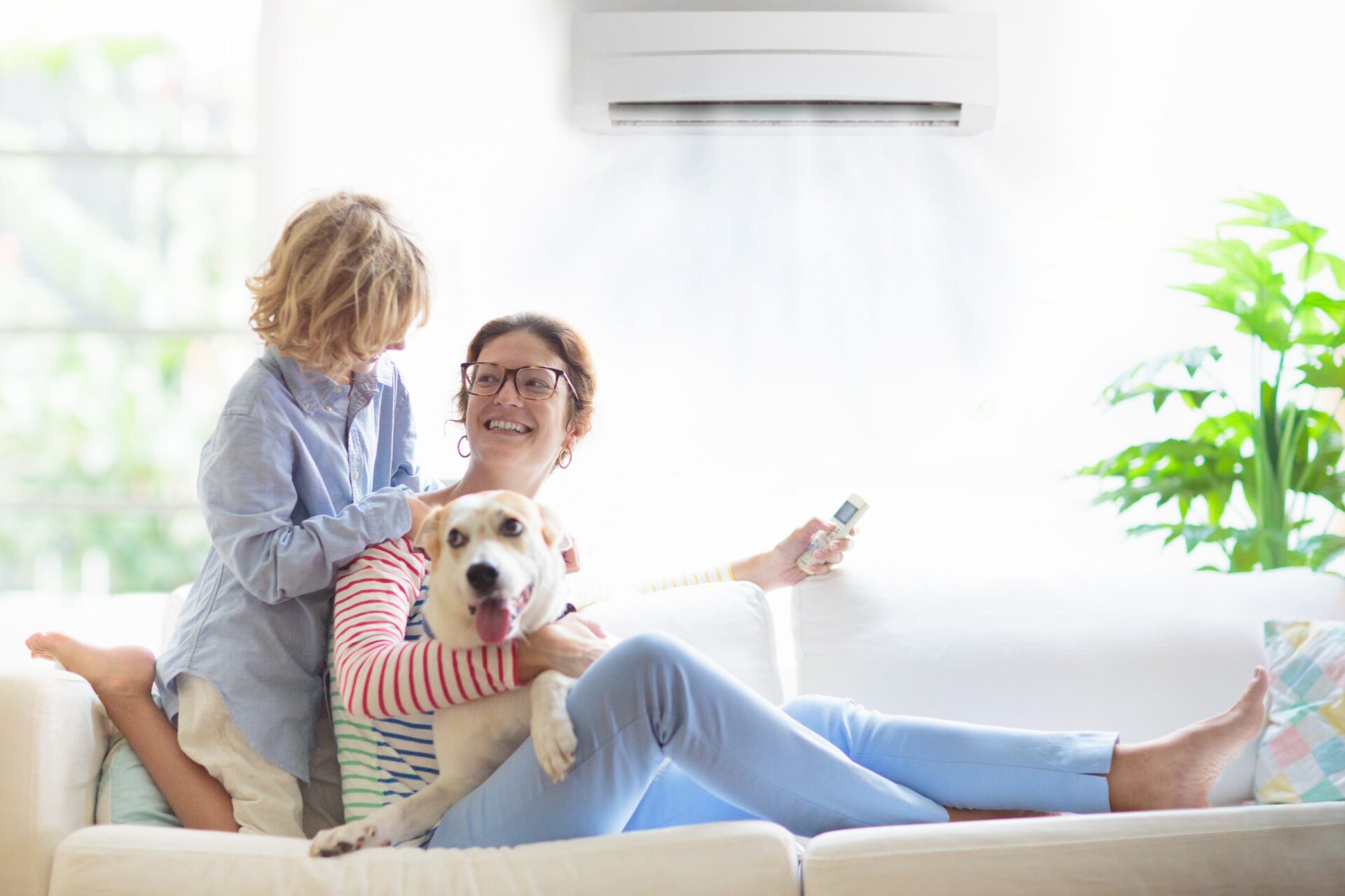 Mother and child with air conditioner remote control Comprehensive Residential Roofing Services<br />